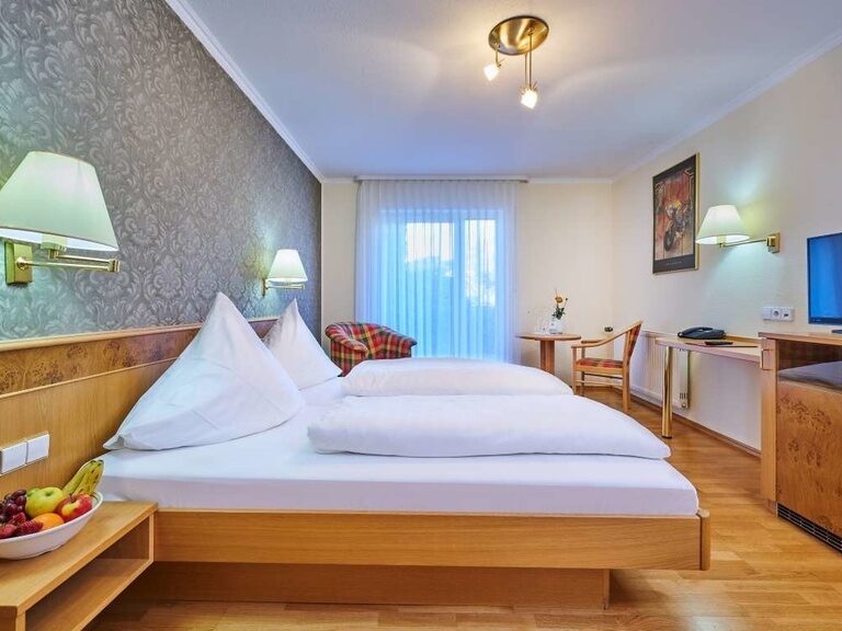 Ein komfortables Bett im gemütlichen Hotelzimmer Auszeit.