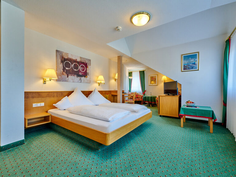 Ein modern gestaltetes Schlafzimmer mit großem Bett und grünem Teppich.