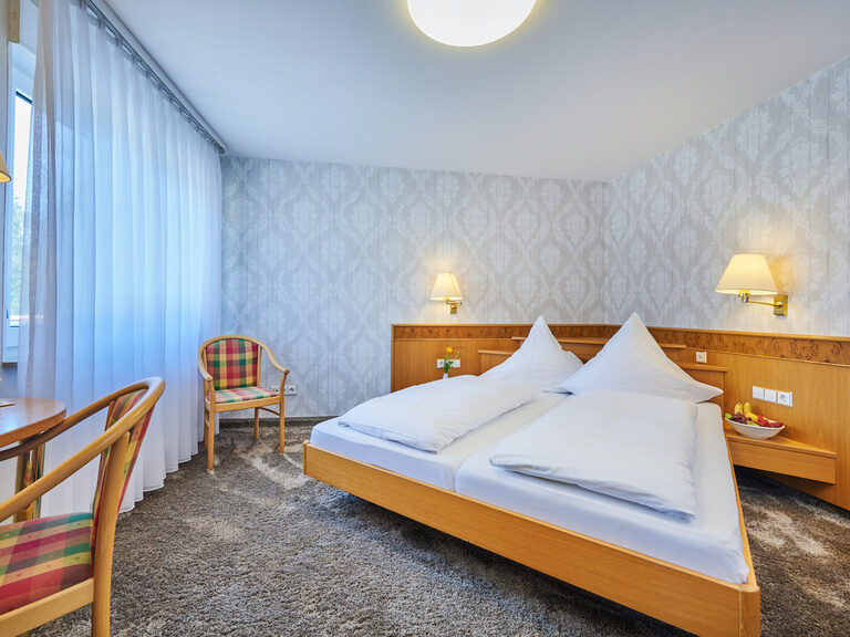 Ein gemütliches Hotelzimmer mit einem großen Bett und stilvollem Schreibtisch.